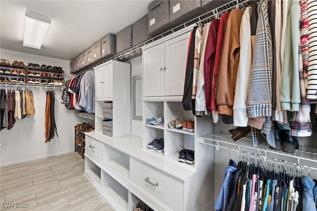 walk in closet with wood finish floors