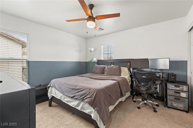 bedroom featuring a ceiling fan, visible vents, and carpet floors