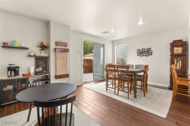 dining room featuring visible vents, wood finished floors, and baseboards