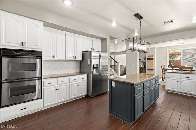 kitchen with visible vents, appliances with stainless steel finishes, white cabinetry, and wood finish floors