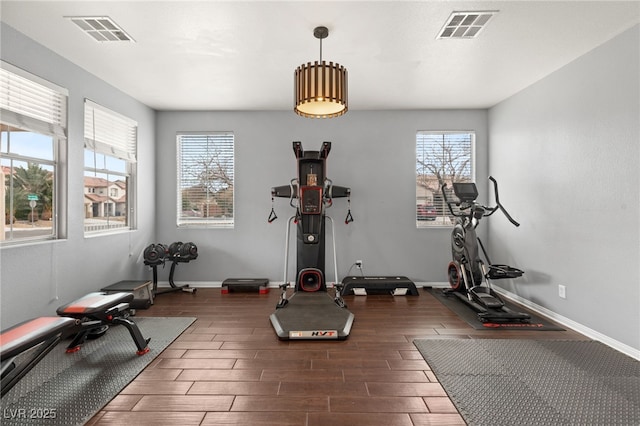 workout area with visible vents, a wealth of natural light, and wood finish floors