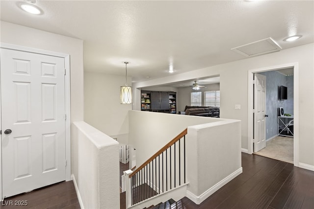 hall featuring dark wood finished floors, attic access, an upstairs landing, and baseboards