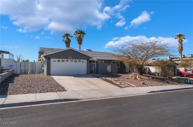 ranch-style house with a gate, fence, stucco siding, concrete driveway, and a garage