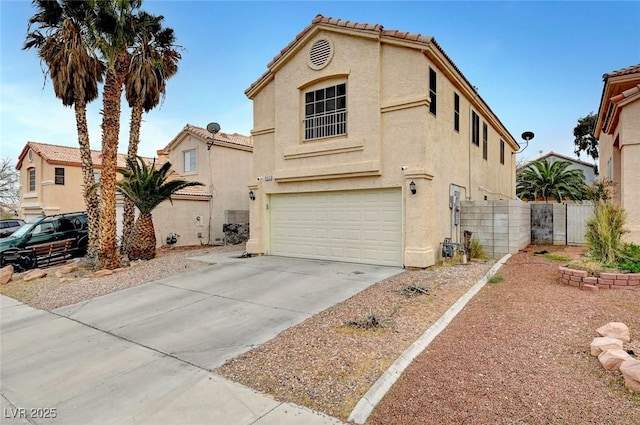 view of front facade with stucco siding, driveway, a tile roof, fence, and a garage