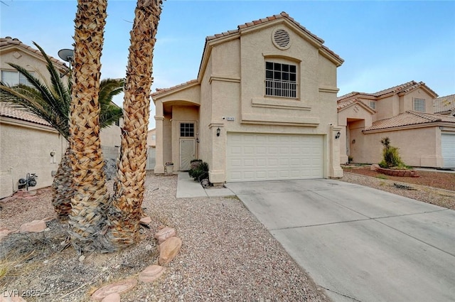 mediterranean / spanish home with a tile roof, concrete driveway, a garage, and stucco siding