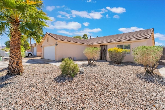 single story home featuring driveway, stucco siding, an attached garage, and a tiled roof