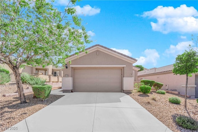 view of front of house featuring stucco siding, driveway, a garage, and fence