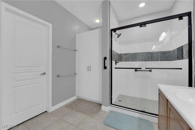 full bathroom with tile patterned floors, a stall shower, vanity, and baseboards