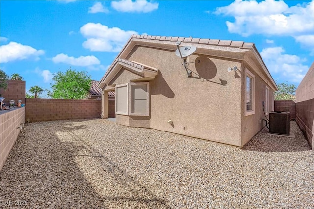 back of property featuring stucco siding, a patio, cooling unit, and a fenced backyard