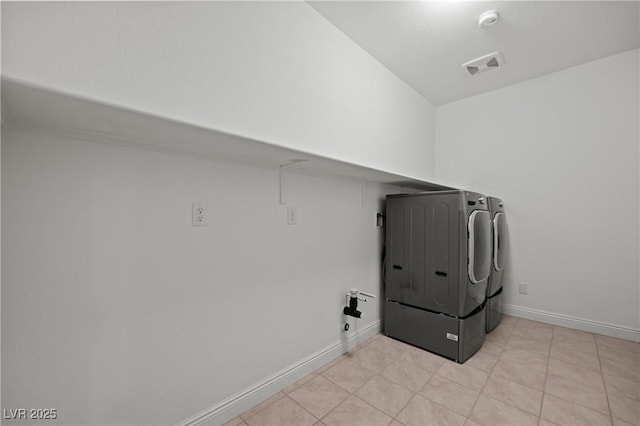 washroom featuring visible vents, separate washer and dryer, light tile patterned floors, baseboards, and laundry area