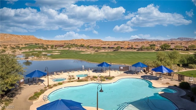 pool featuring a mountain view, fence, a community hot tub, and a patio area