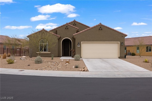 mediterranean / spanish-style home featuring fence, a tiled roof, concrete driveway, stucco siding, and an attached garage