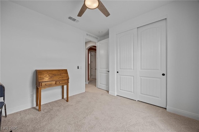 carpeted bedroom with visible vents, arched walkways, and baseboards