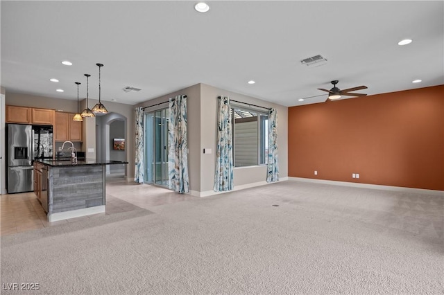 kitchen featuring visible vents, recessed lighting, arched walkways, and stainless steel fridge