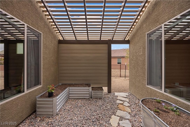 exterior space with a garden, fence, and a pergola