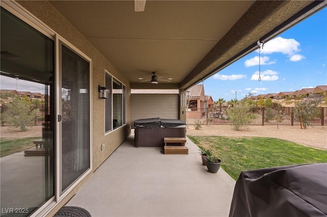 view of patio with grilling area, a hot tub, a ceiling fan, and fence