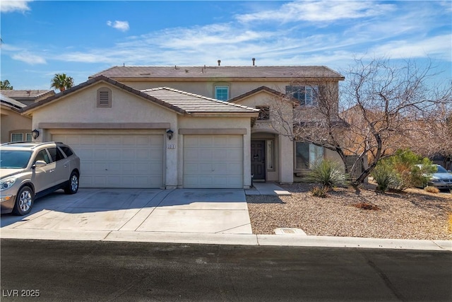 traditional-style home featuring a tiled roof, stucco siding, driveway, and a garage