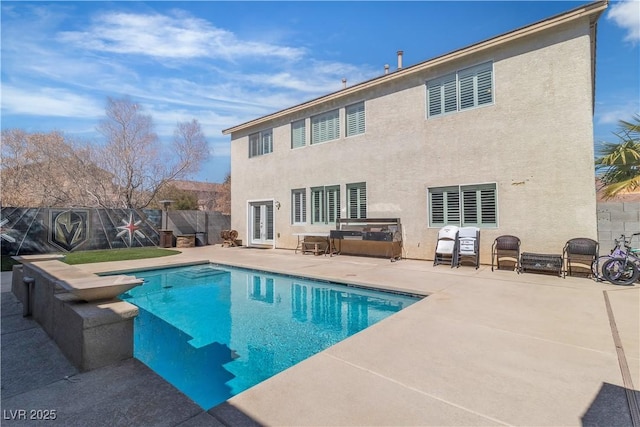 rear view of property featuring stucco siding, a patio, a fenced backyard, french doors, and a fenced in pool