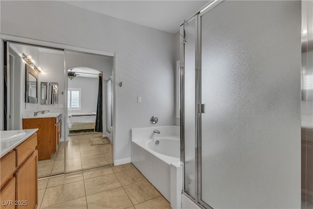 full bathroom with a garden tub, two vanities, a sink, a shower stall, and tile patterned flooring