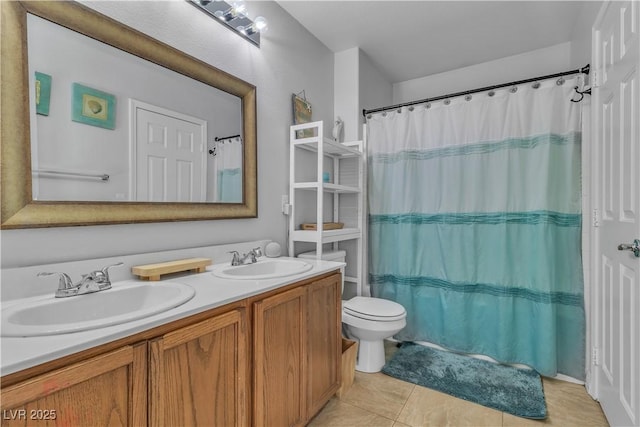 full bath featuring double vanity, tile patterned floors, toilet, and a sink