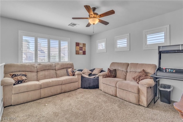 carpeted living area with visible vents and a ceiling fan