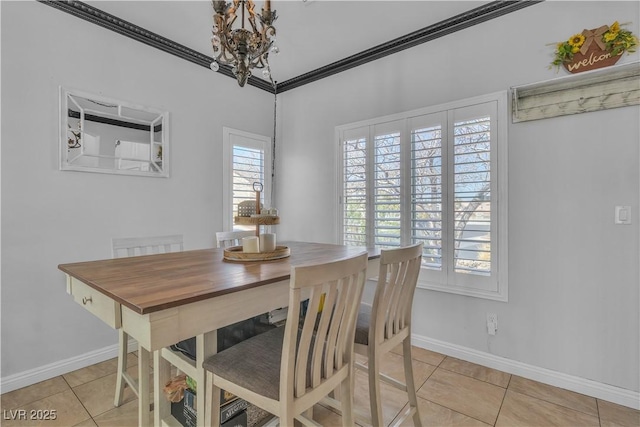 dining area featuring baseboards, a notable chandelier, light tile patterned flooring, and crown molding