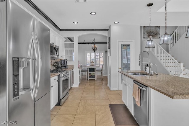 kitchen featuring a sink, stainless steel appliances, white cabinets, light tile patterned floors, and a chandelier