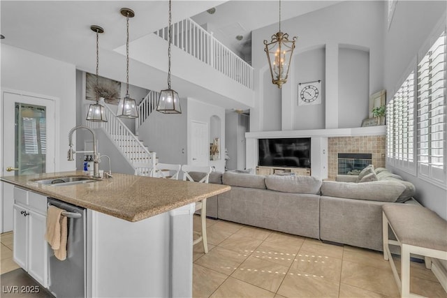 kitchen with light stone countertops, a sink, hanging light fixtures, white cabinets, and a chandelier