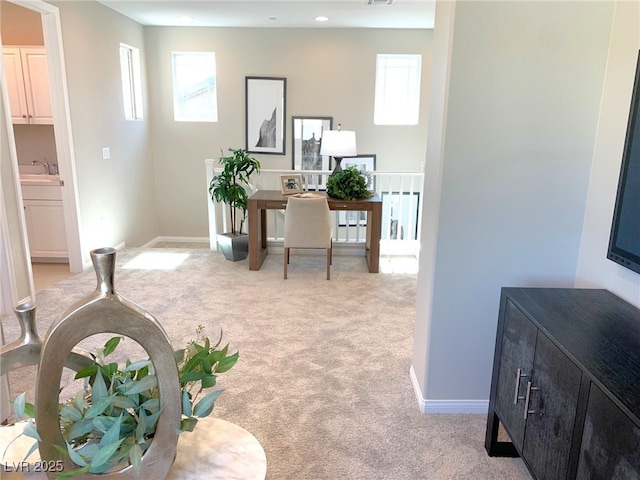 carpeted office space with visible vents, recessed lighting, baseboards, and a sink