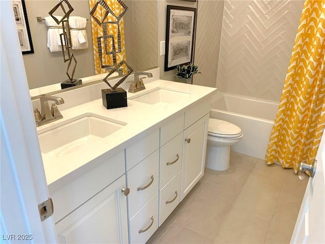 bathroom featuring tile patterned flooring, double vanity, toilet, and a sink