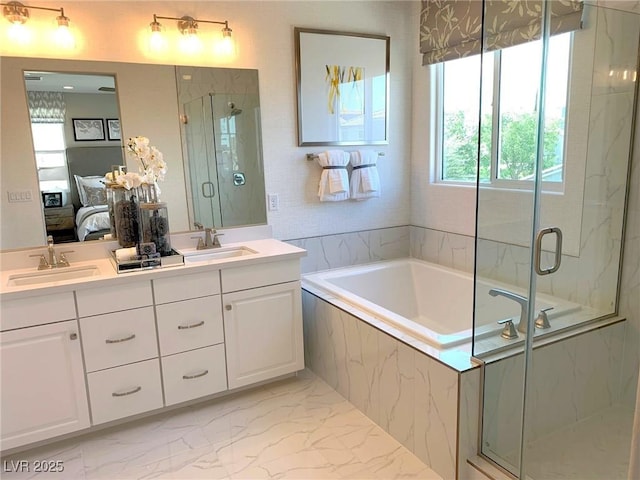 ensuite bathroom with a marble finish shower, connected bathroom, marble finish floor, and a sink