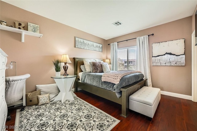 bedroom with wood finished floors, visible vents, and baseboards