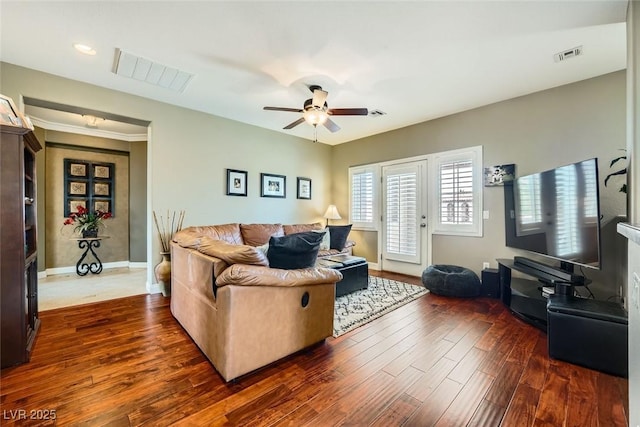 living area featuring a ceiling fan, dark wood-style floors, visible vents, and baseboards