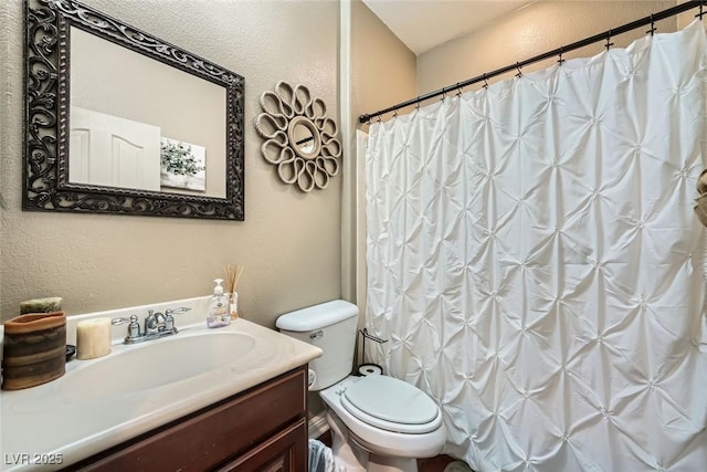 full bath with a shower with shower curtain, toilet, vanity, and a textured wall