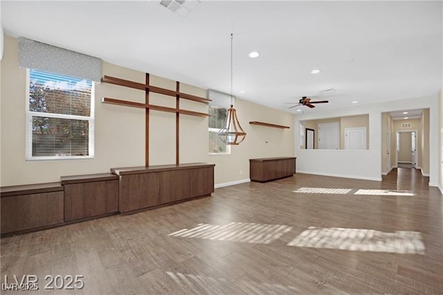 unfurnished living room featuring wood finished floors, visible vents, and a healthy amount of sunlight