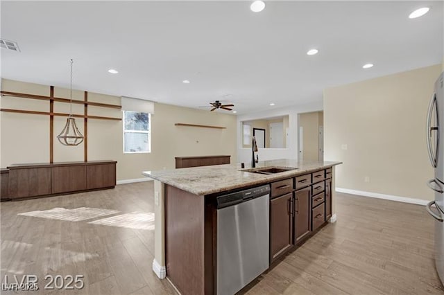 kitchen featuring light wood finished floors, visible vents, an island with sink, appliances with stainless steel finishes, and a sink