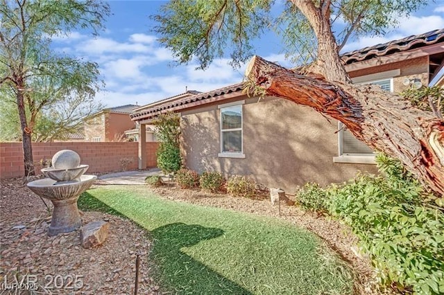 view of side of property with fence and stucco siding