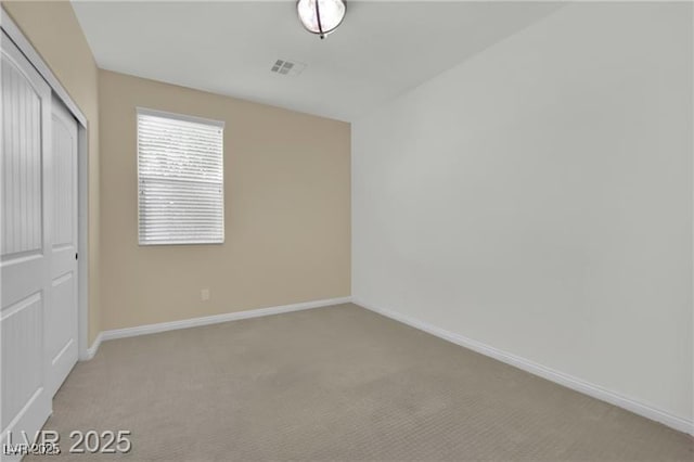 unfurnished bedroom with visible vents, baseboards, light colored carpet, and a closet