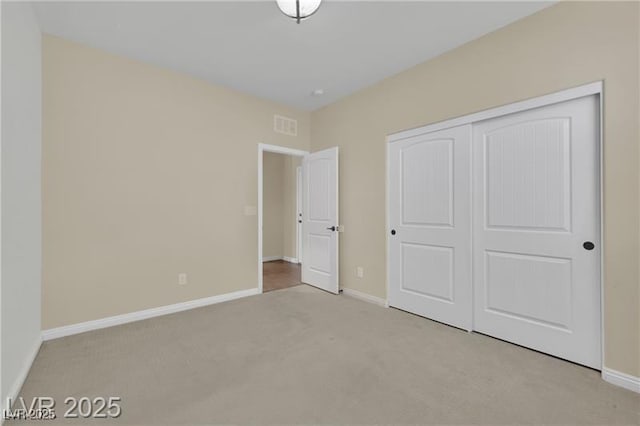 unfurnished bedroom with a closet, baseboards, carpet, and visible vents