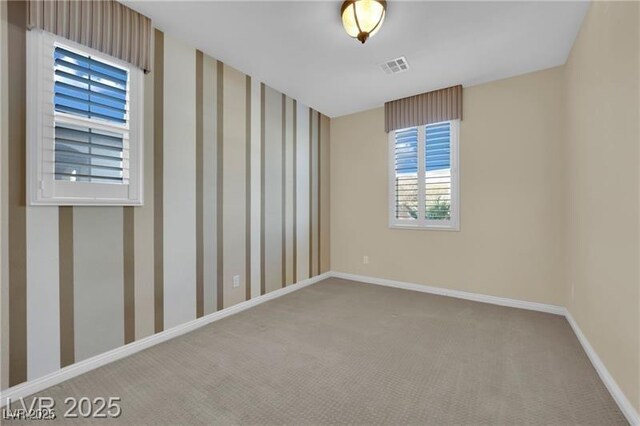 empty room featuring visible vents, baseboards, carpet floors, and wallpapered walls