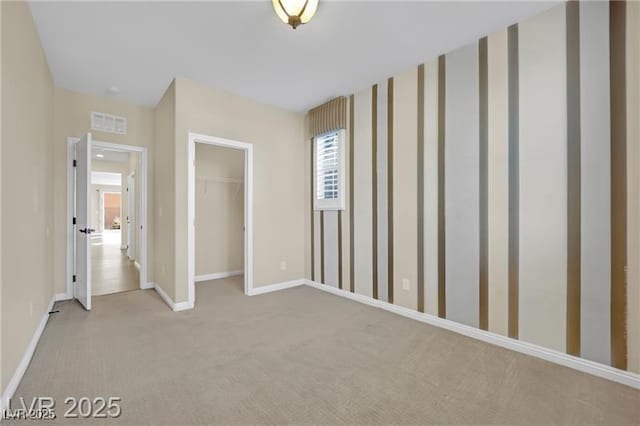 unfurnished bedroom with a closet, visible vents, baseboards, and carpet