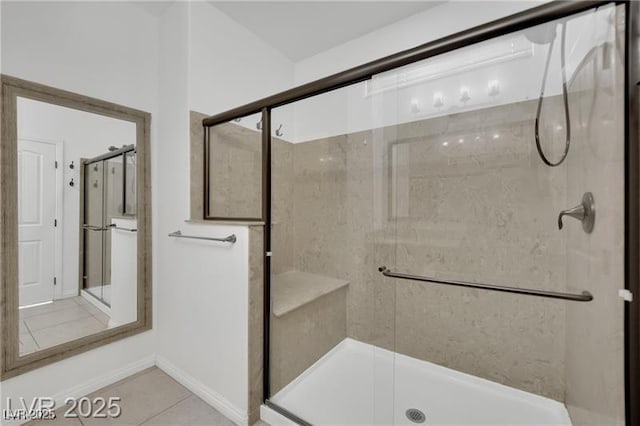 full bath featuring tile patterned flooring, baseboards, and a stall shower