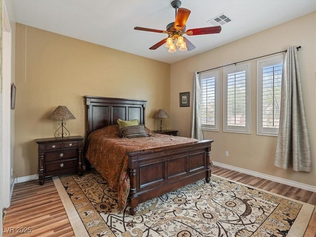 bedroom with ceiling fan, baseboards, visible vents, and light wood-type flooring