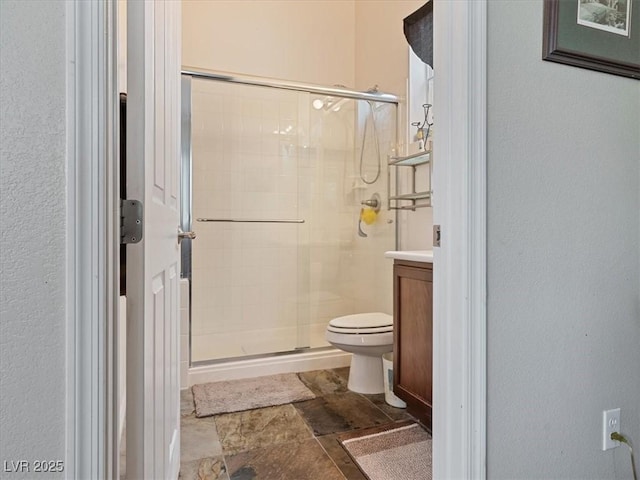 full bath with vanity, toilet, and a stall shower