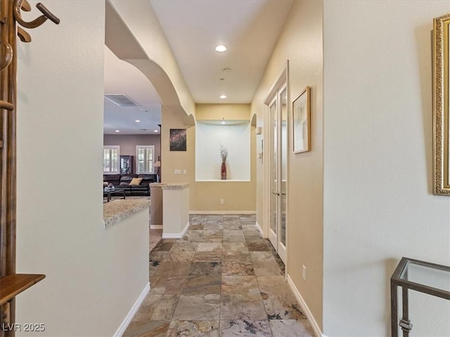 hall with recessed lighting, visible vents, baseboards, and stone finish flooring