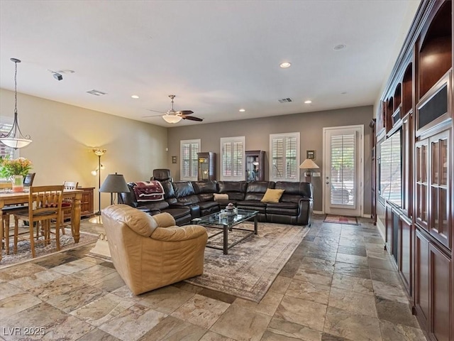 living room featuring a ceiling fan, stone tile floors, recessed lighting, and visible vents