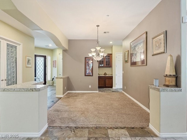 foyer entrance featuring visible vents, baseboards, carpet floors, recessed lighting, and arched walkways