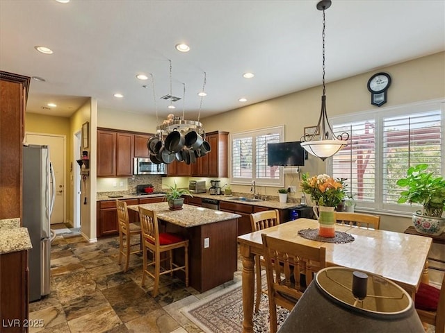 kitchen featuring a sink, tasteful backsplash, a kitchen island, recessed lighting, and appliances with stainless steel finishes