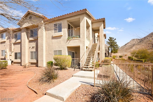 view of property featuring a mountain view, stairs, and fence