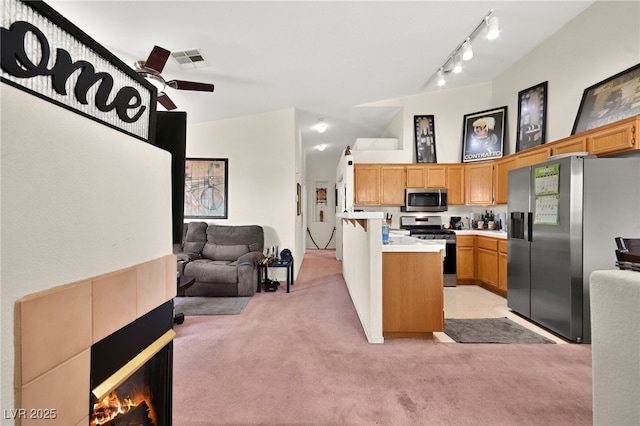 kitchen featuring visible vents, stainless steel appliances, light countertops, light colored carpet, and open floor plan